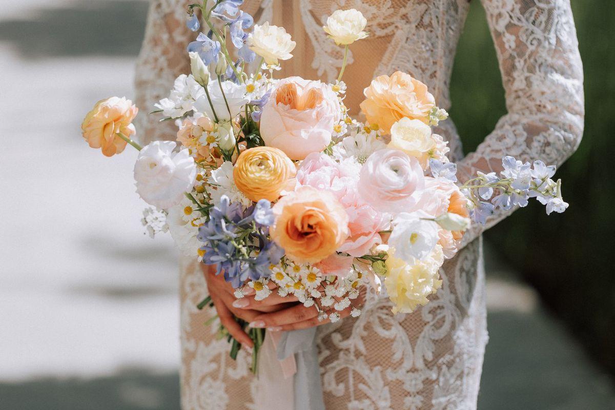 Bride holding a blush and peach wedding bouquet