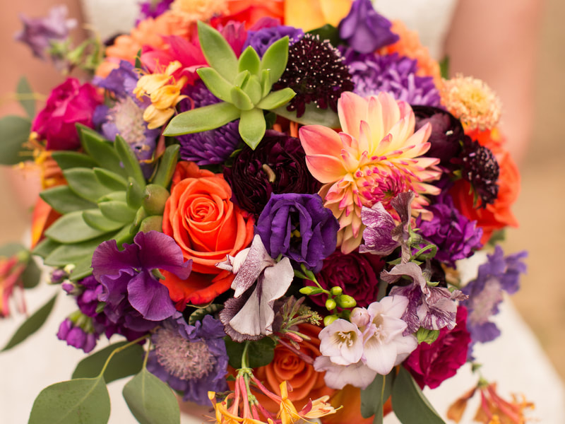 Bridal bouquet, bride’s bouquet with flowers done by Sweet Elegance Floral design florist in Kelowna, BC.
Hand tied bouquet with roses, lisianthus, dahlias, roses and sedums in bright colours of orange, purple, pink, yellow and green.

