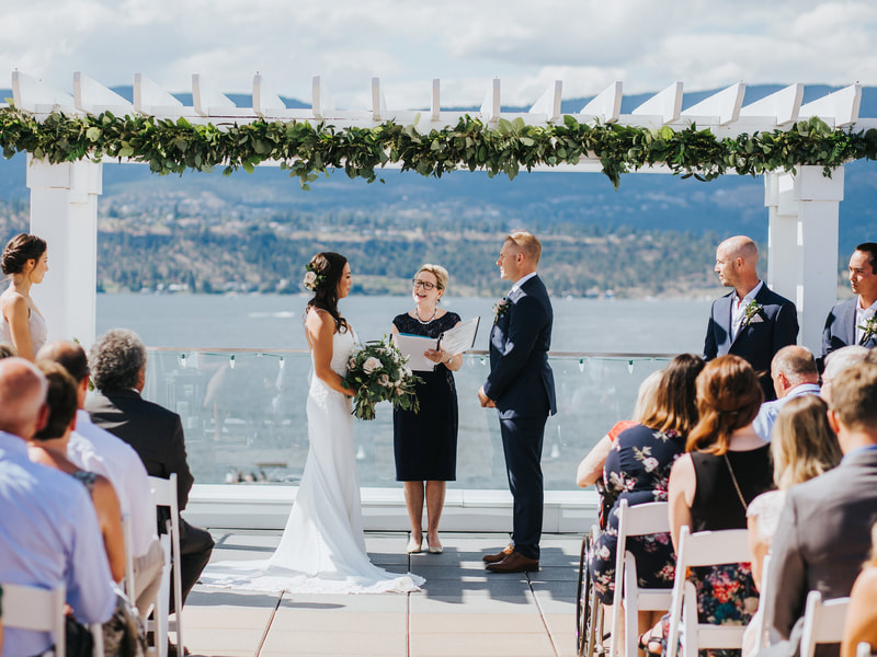Wedding of Bride Julie and Groom Mike, outdoor ceremony at Hotel Eldorado in Kelowna, BC.  On a clear, bright day overlooking Lake Okanagan.  Groomsmen boutonniere and bridal hairpiece of roses and thistles.  Brides bouquet of pink and white roses, spray roses, thistles and greenery.  Wedding photos taken by Barnett Photography.  Wedding flowers done by Sweet Elegance Floral design, florist in Kelowna, BC.  